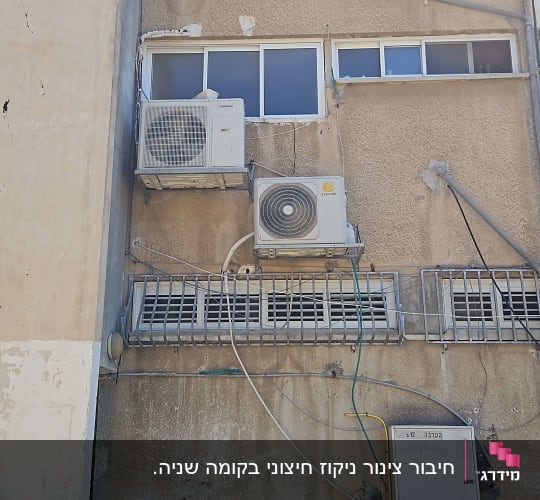 שני מזגנים מותקנים על קיר חיצוני של בניין